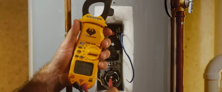 Clamp meter testing the electrical connections on a water heater