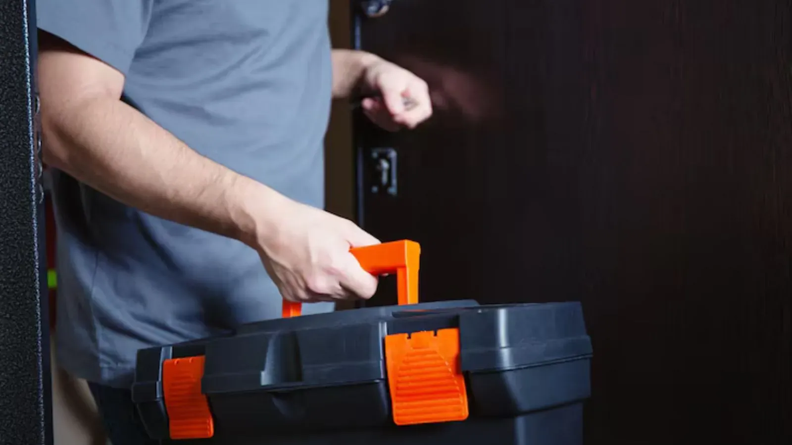 Plumber lifting a toolbox before heading out on a service call
